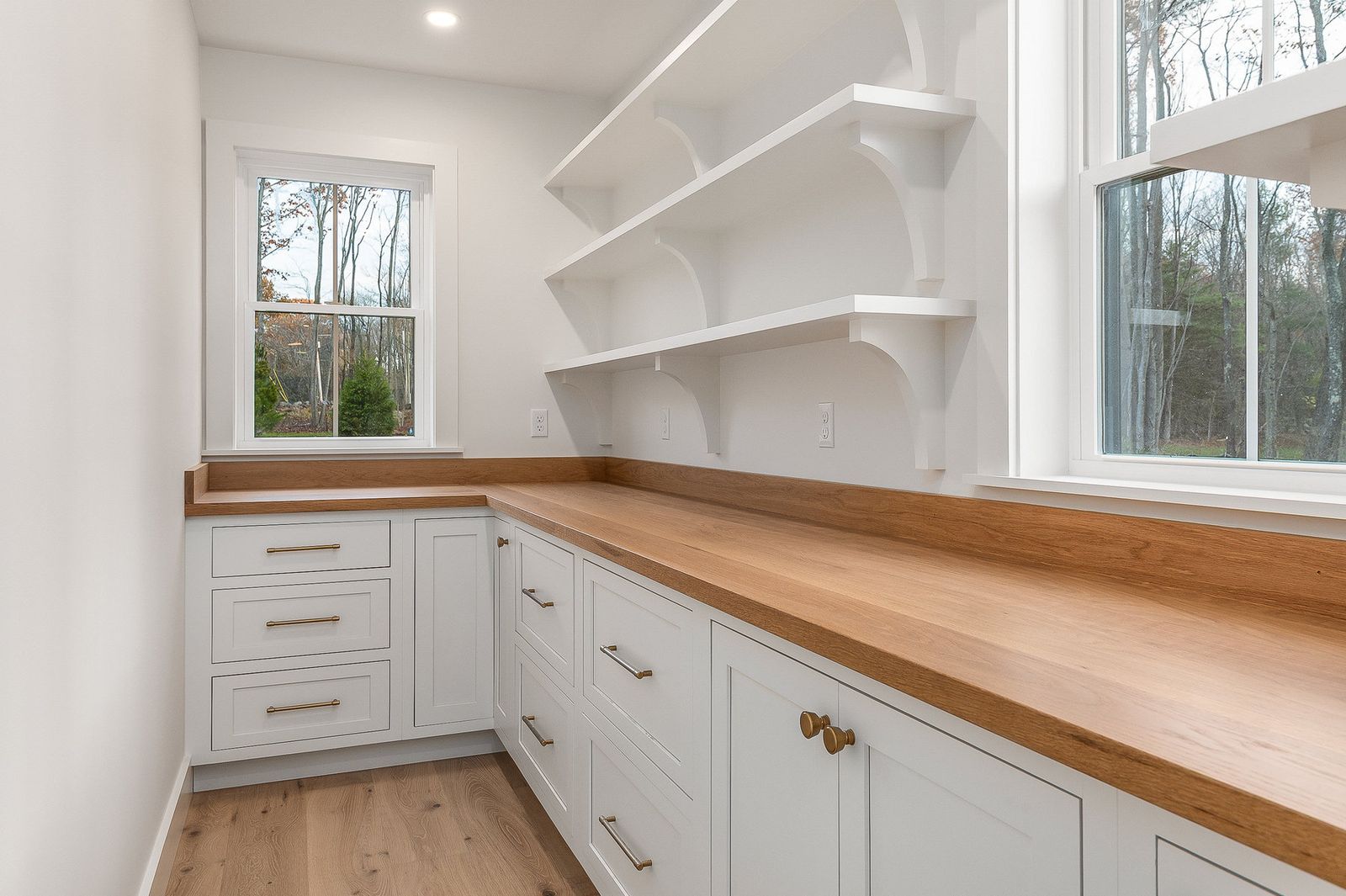 Butler pantry with butcher block counters, white cabinets and open shelving - a River Birch Builders home in the New Hampshire Seacoast
